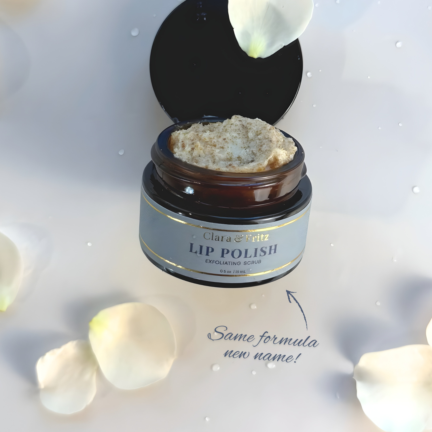 Jar of Clara & Fritz Lip Polish with white flowers on a light background
