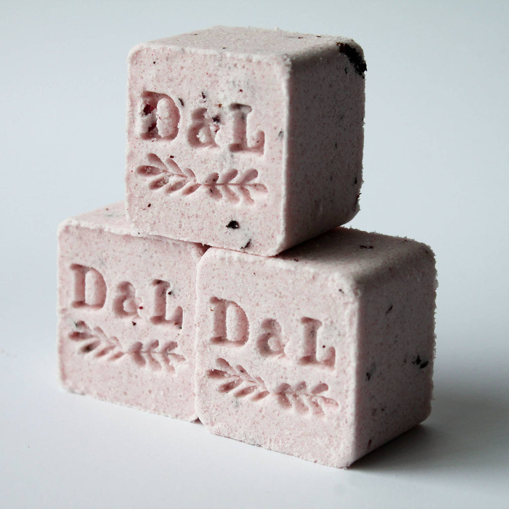 Two pink soap bars with 'D&L' branding on a light gray background