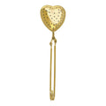 Gold heart-shaped tea infuser on a white background