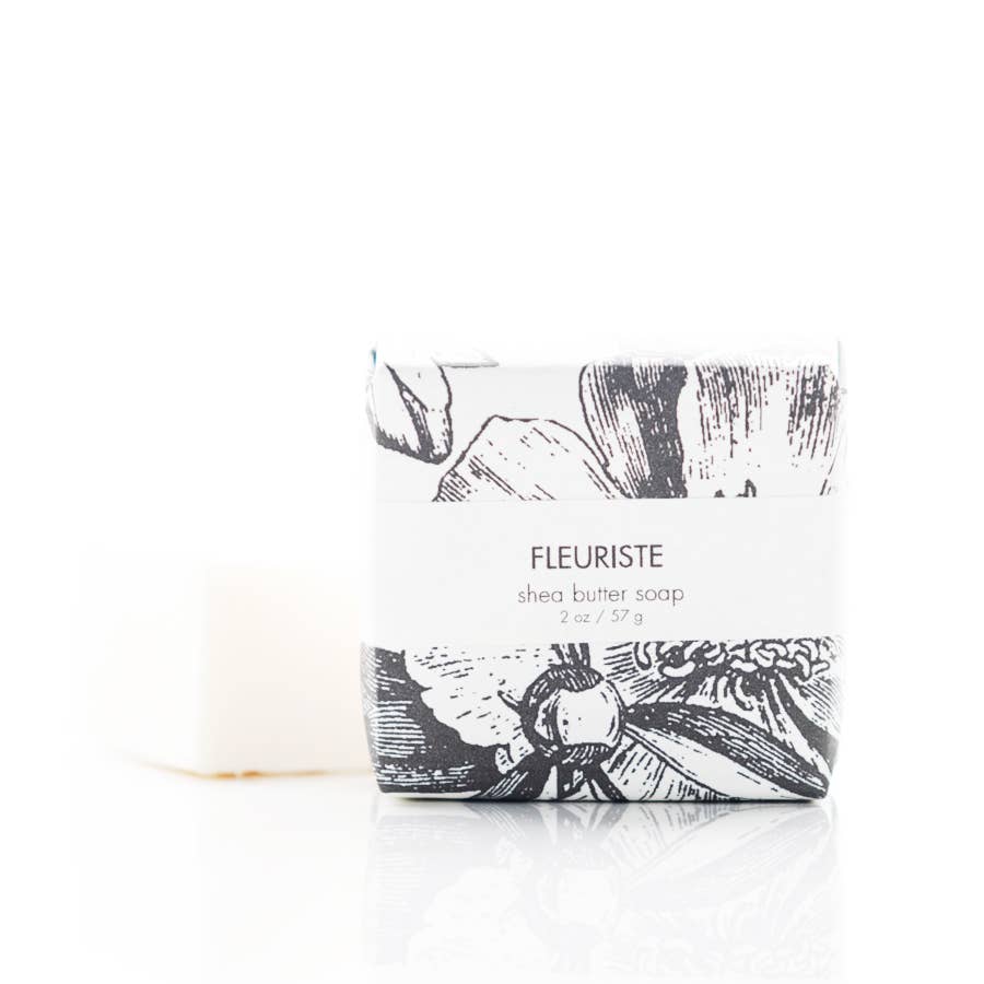 Shea butter soap bar with black and white design and 'Fleuriste' branding on a white background