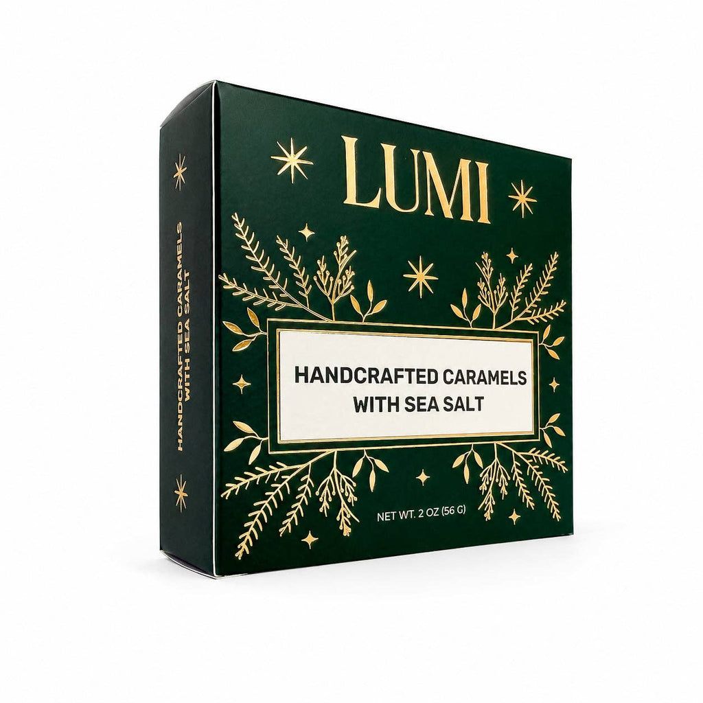 Lumi Handcrafted Caramels with Sea Salt in a dark green box with gold botanical and star illustrations, shown on a clean white background.