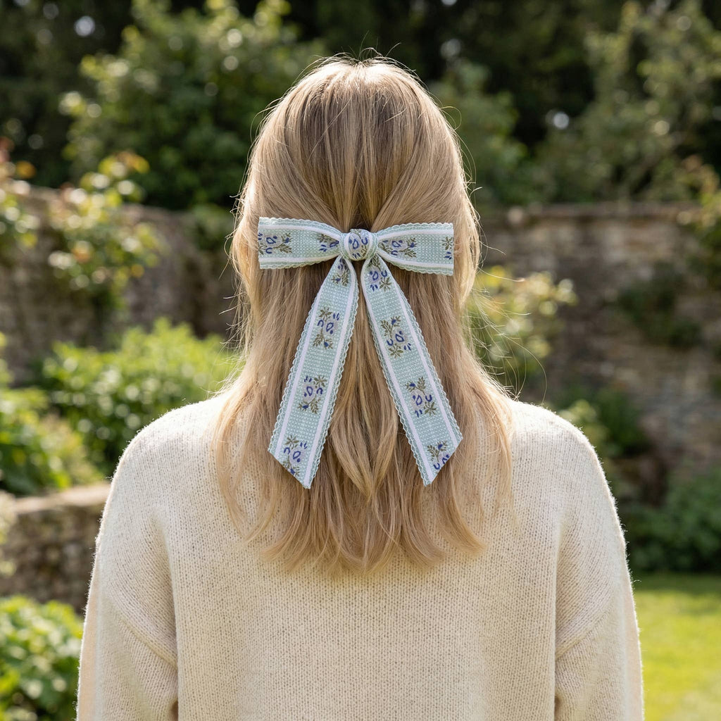 Person with floral ribbon in hair outdoors