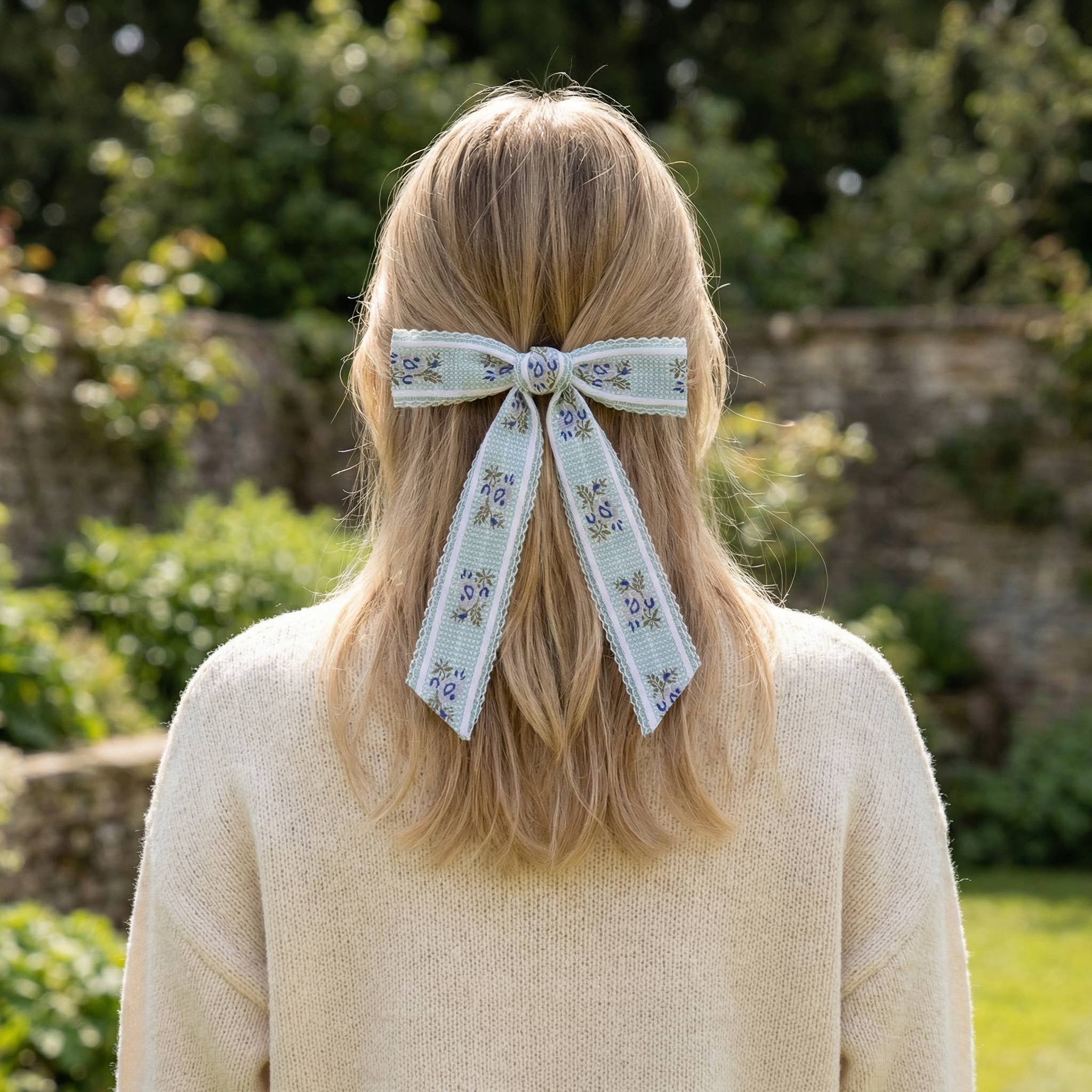 Person with floral ribbon in hair outdoors