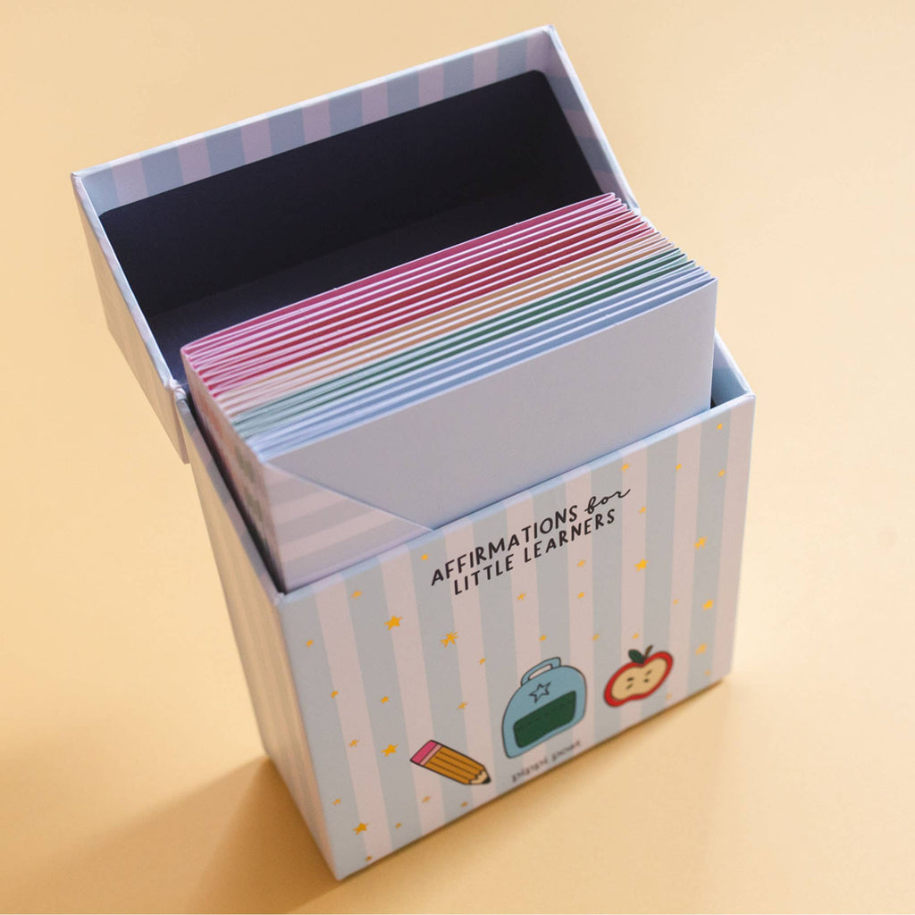 Box of colorful affirmation cards for children on a beige background
