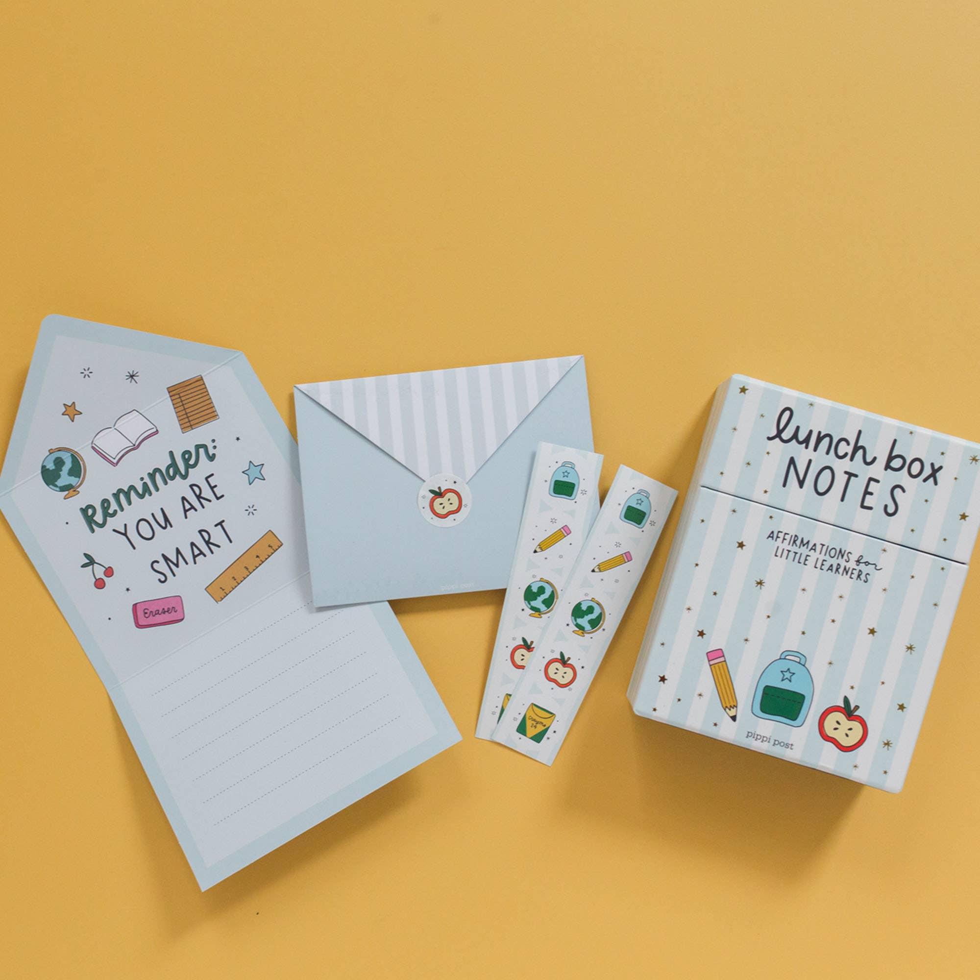 Notebook, stationery items, and lunch box notes on a yellow background