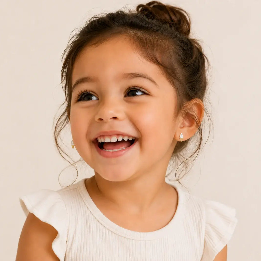 Young girl with a big smile wearing a white top against a plain background