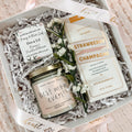 Gift set with candle, chocolate bar, and flowers in a box