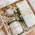 Gift set with candle, chocolate, and other items in a decorative box.