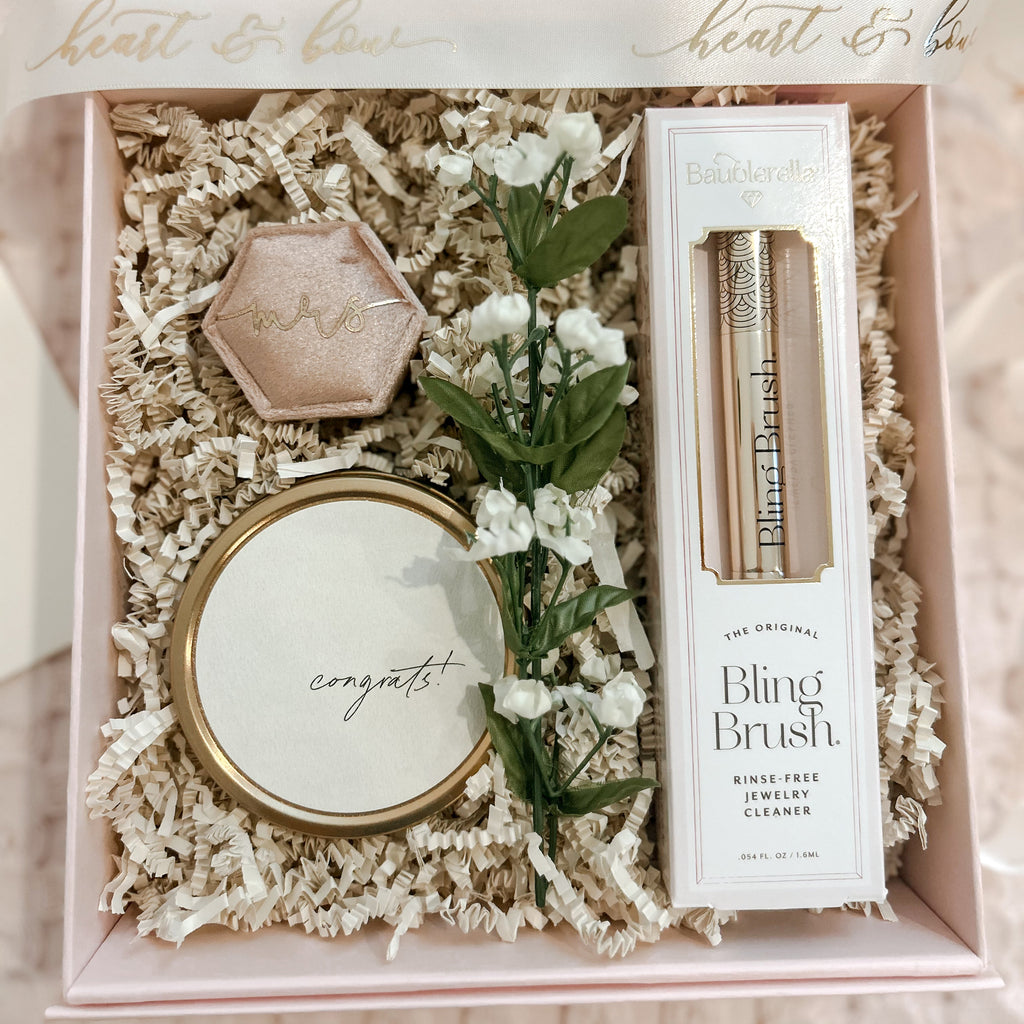 Gift set with 'congrats' card, hexagonal object, and 'Bling Brush' in a decorative box.