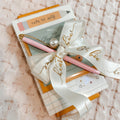 Notebook with pen and decorative bow on a textured surface