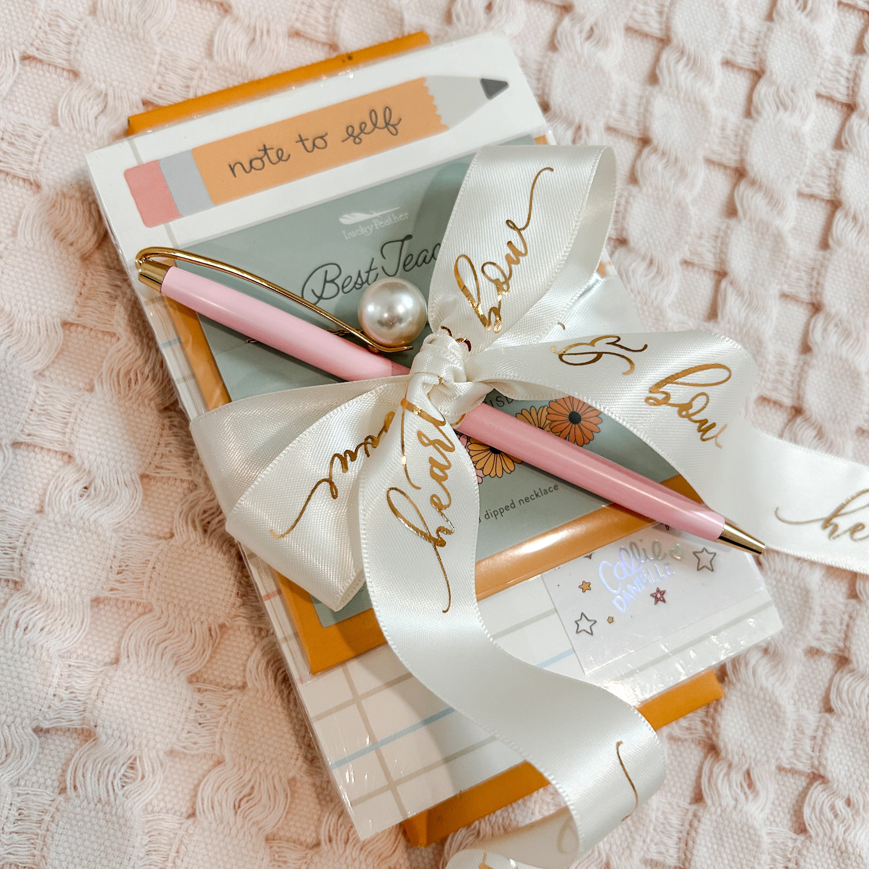 Notebook with pen and decorative bow on a textured surface
