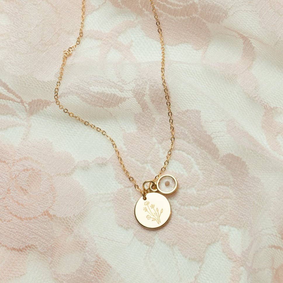 Gold necklace with circular pendants on a floral-patterned background