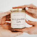 Jar of 'best grandma ever' candle held by hands with a light background