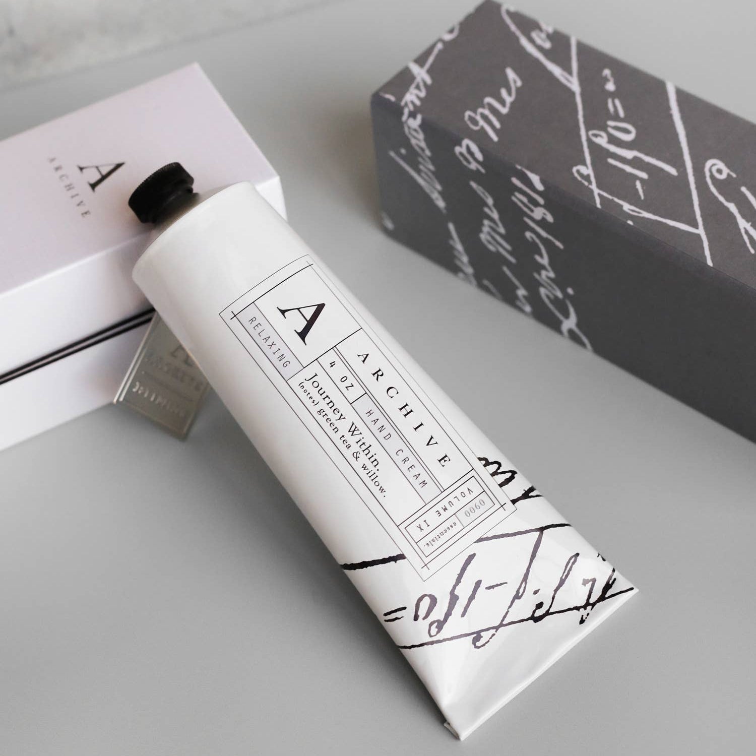 Hand cream with a branded box on a light gray surface