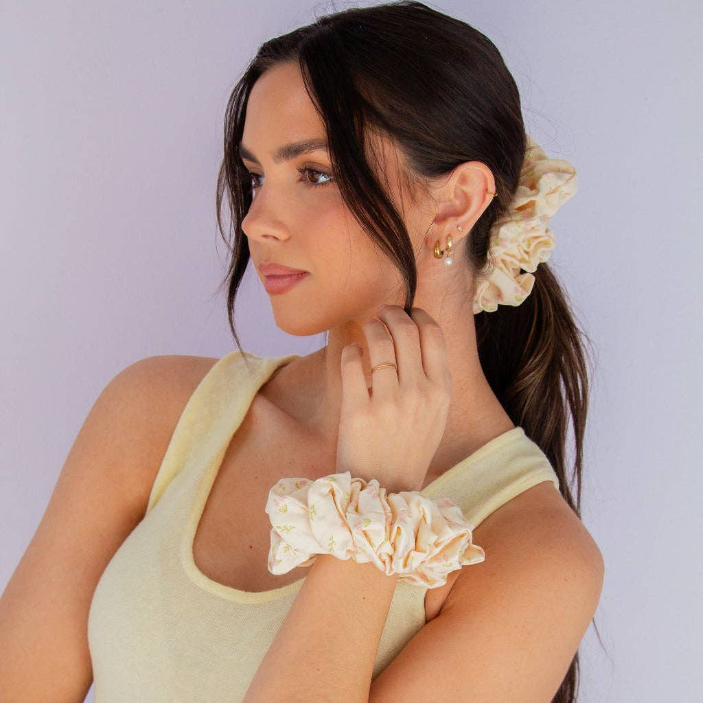 Woman wearing a yellow tank top with ruffled sleeves against a plain background