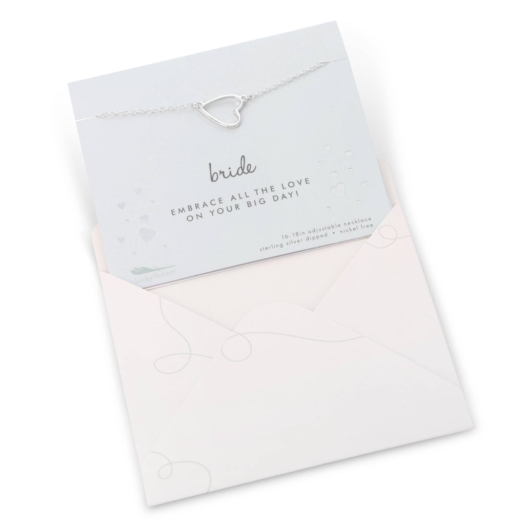 Silver bracelet with a heart design on a white card, placed inside an open white envelope.