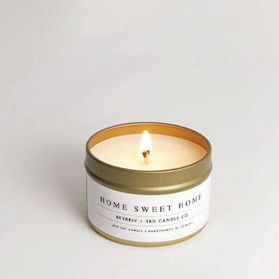 Candle in a tin with 'Home Sweet Home' label on a light gray background