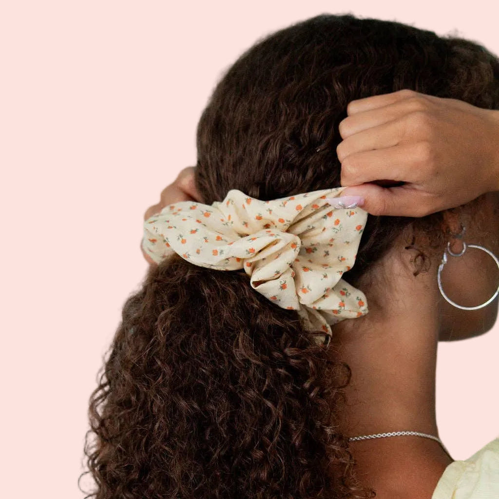 Honey Blossoms jumbo scrunchie featuring a soft cream fabric with warm honey floral print, styled in a ponytail.