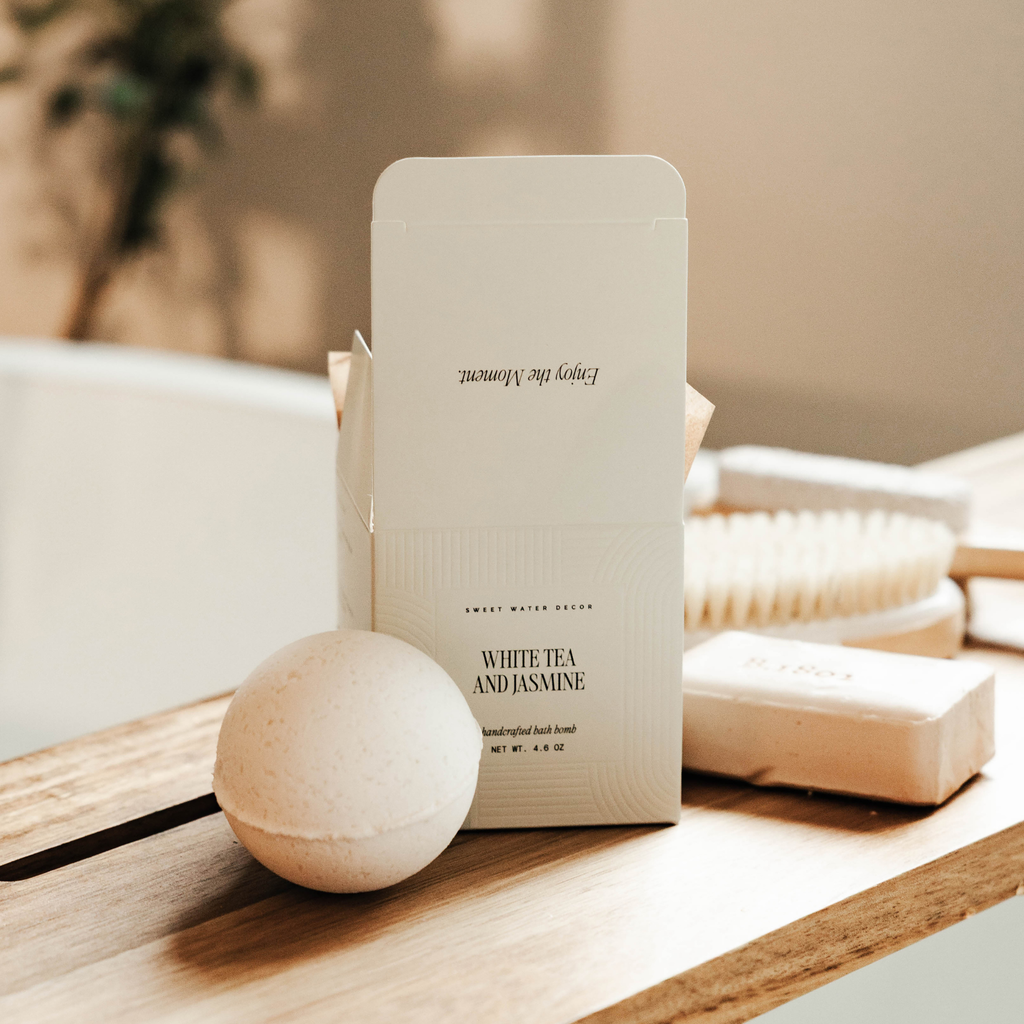White tea and jasmine product packaging on a wooden surface with a blurred background