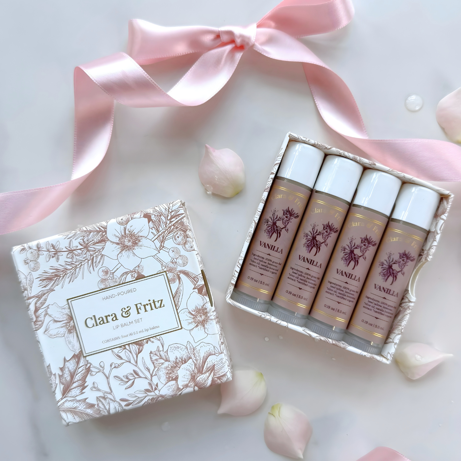 Set of skincare products with a decorative box and pink ribbon on a light background