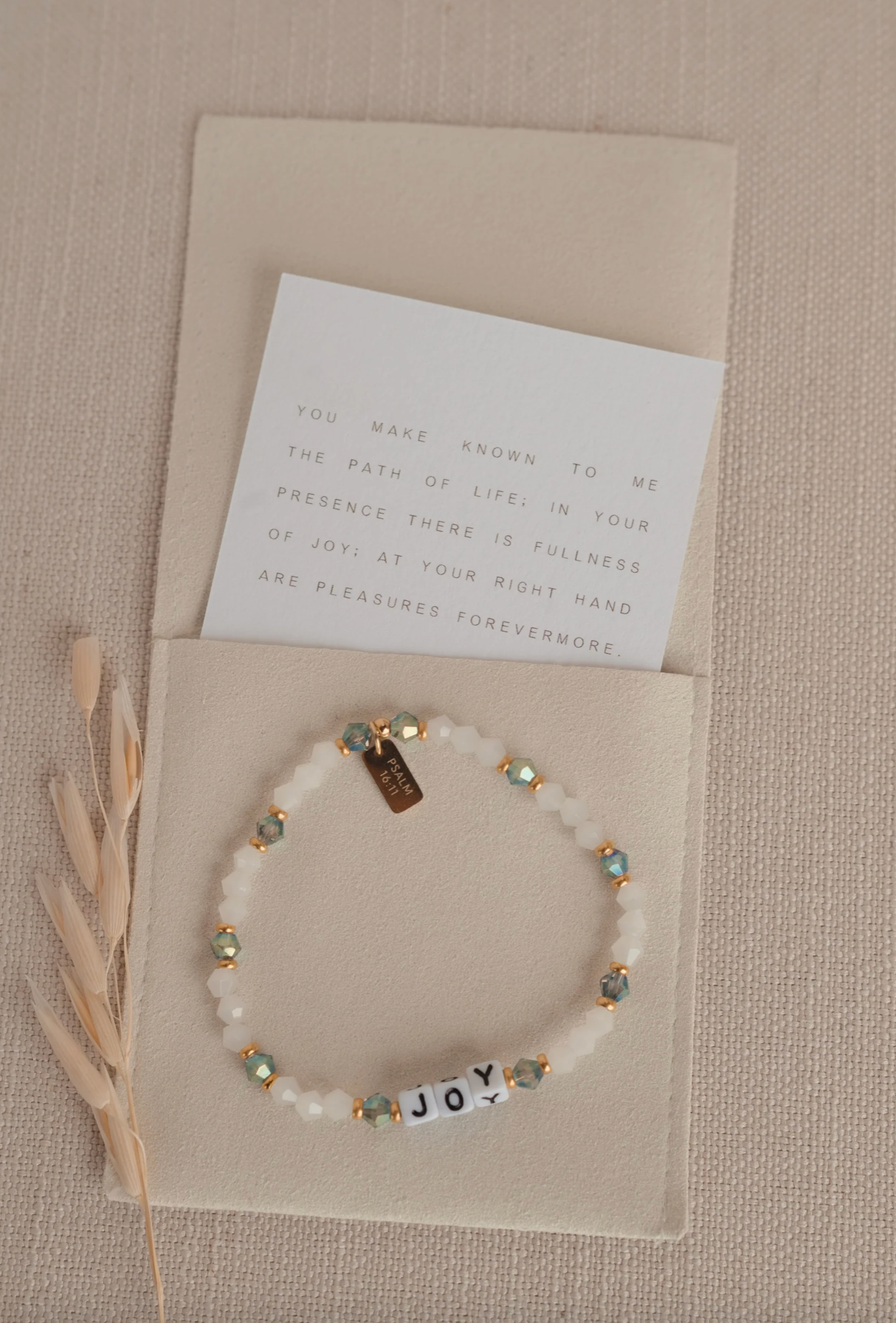 Bracelet with 'JOY' beads on a beige card with text
