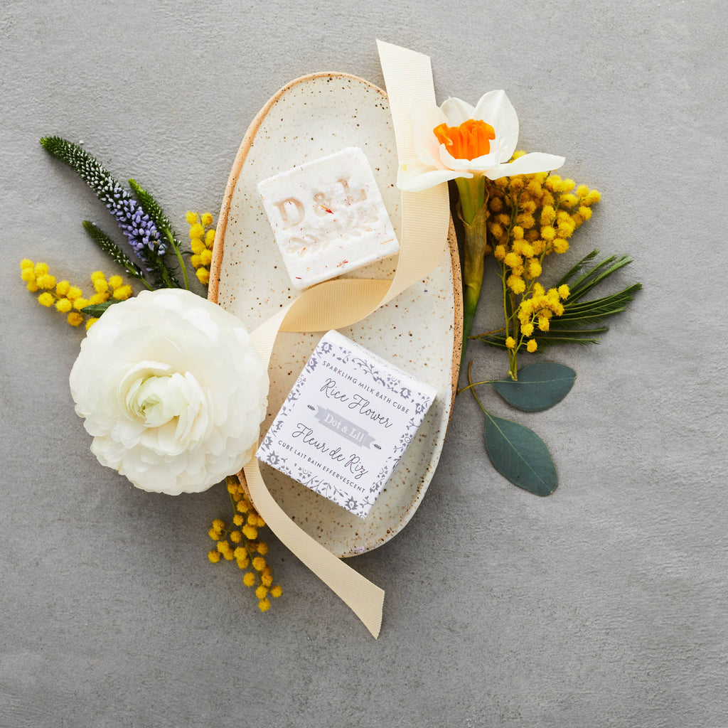 Decorative arrangement with flowers and a small card on a gray background