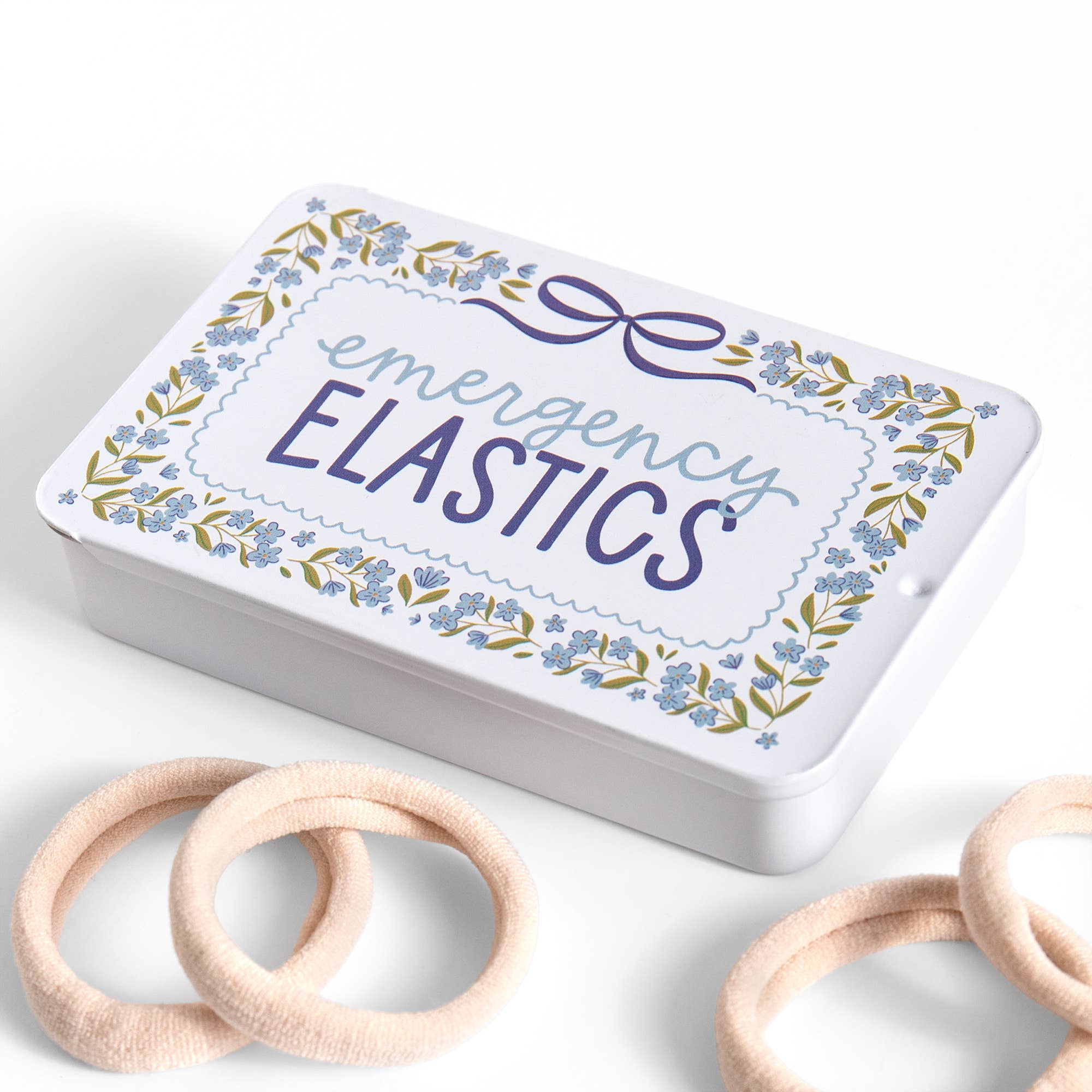 Box labeled 'emergency elastics' with wooden elastics on a white background