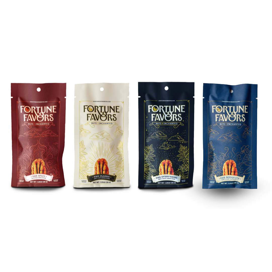 Four stand-up pouches of Fortune Favors candy arranged in a row on a white background. The packages are in burgundy, cream, dark navy, and medium blue, each featuring gold decorative patterns and an illustration of a candy cane at the bottom.