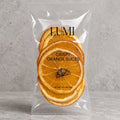 upright package: LUMI crispy dried orange slices in a clear 0.3 oz pouch against a gray background.
