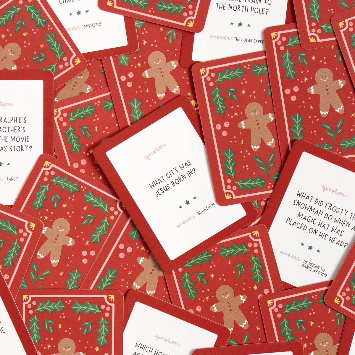 Christmas-themed trivia cards with gingerbread men and holly leaves on a red background.