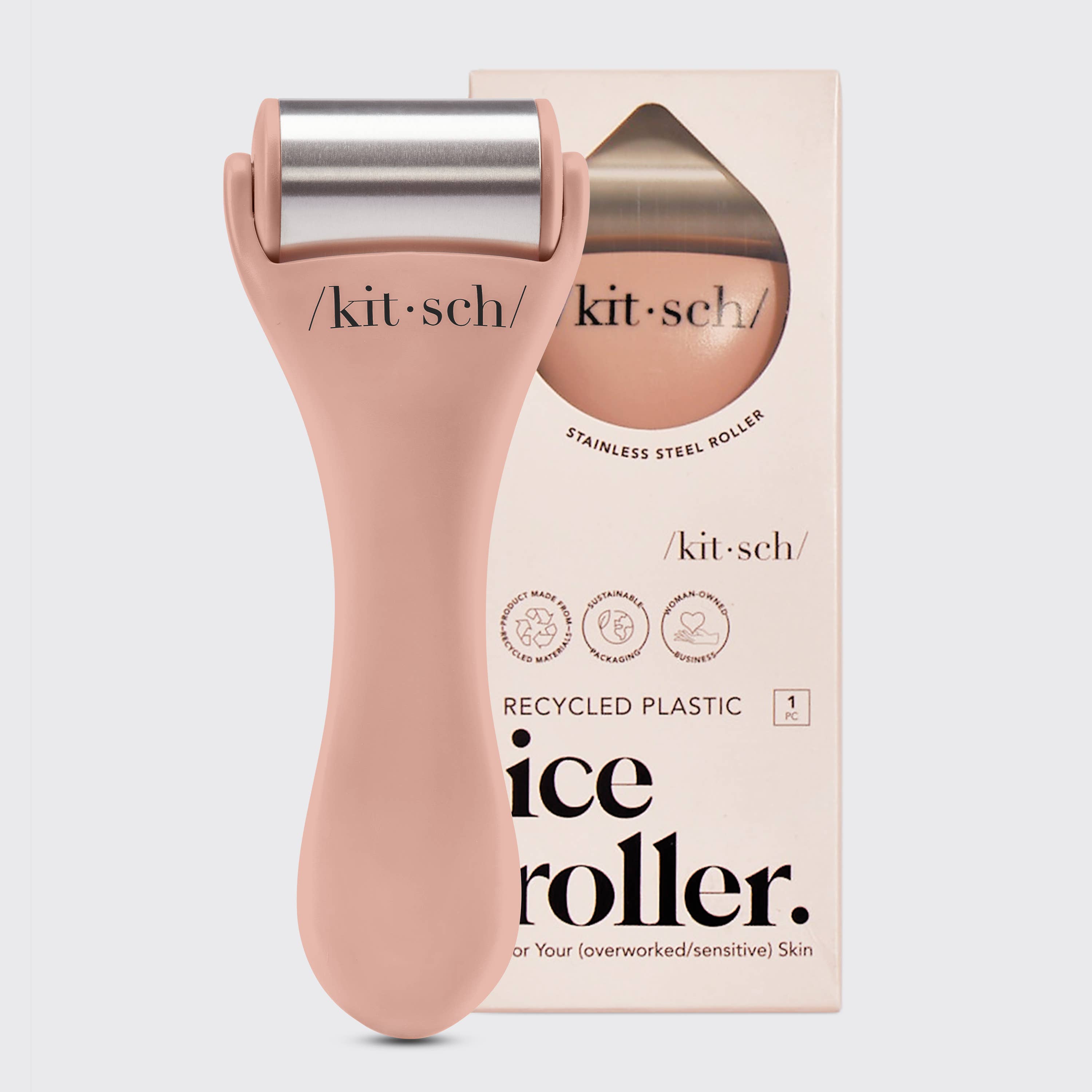 Pink ice roller with silver top next to its packaging on a light gray background