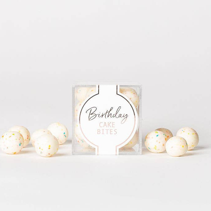 Packaged birthday cake batter with decorative balls on a light gray background