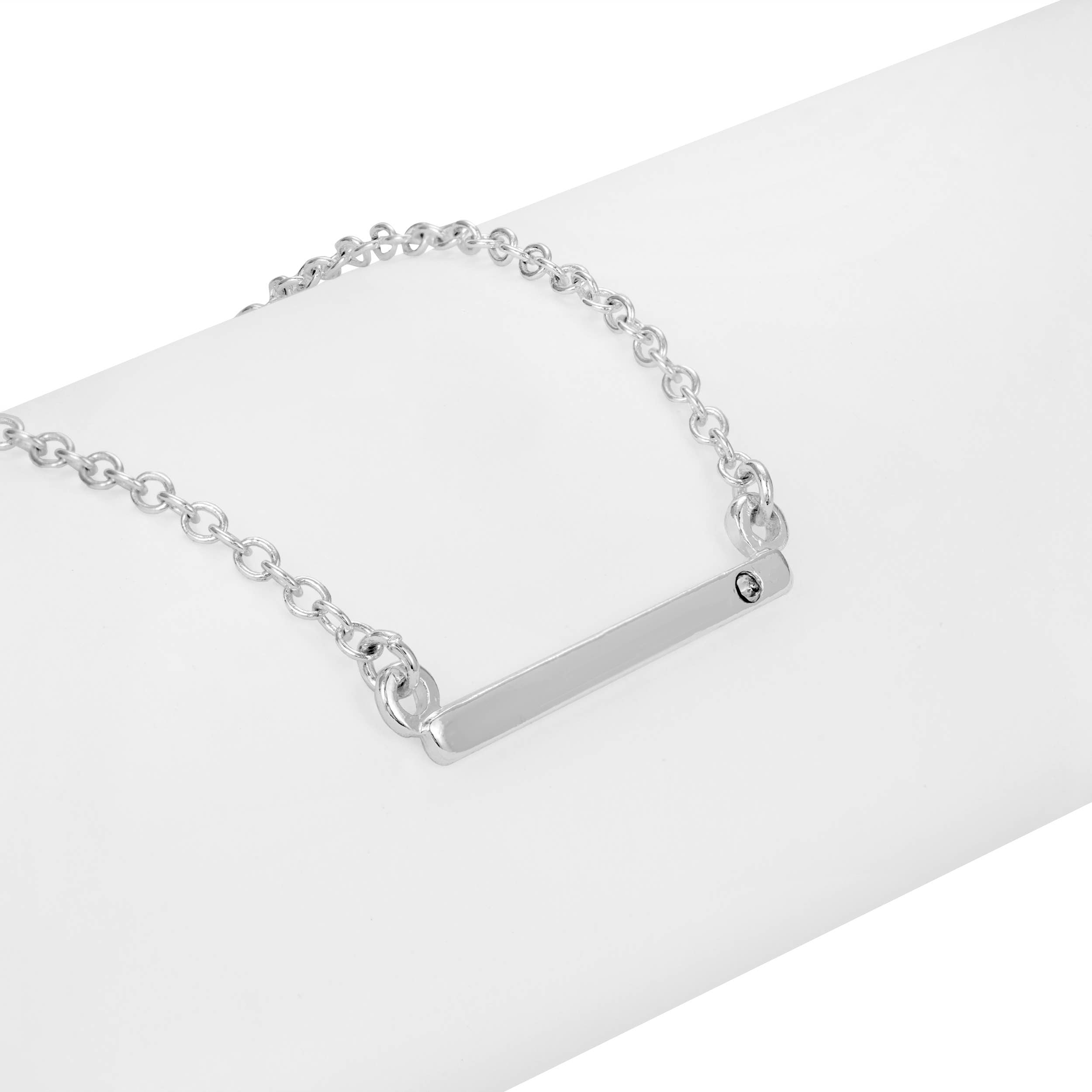 Silver bracelet with a bar clasp on a white surface