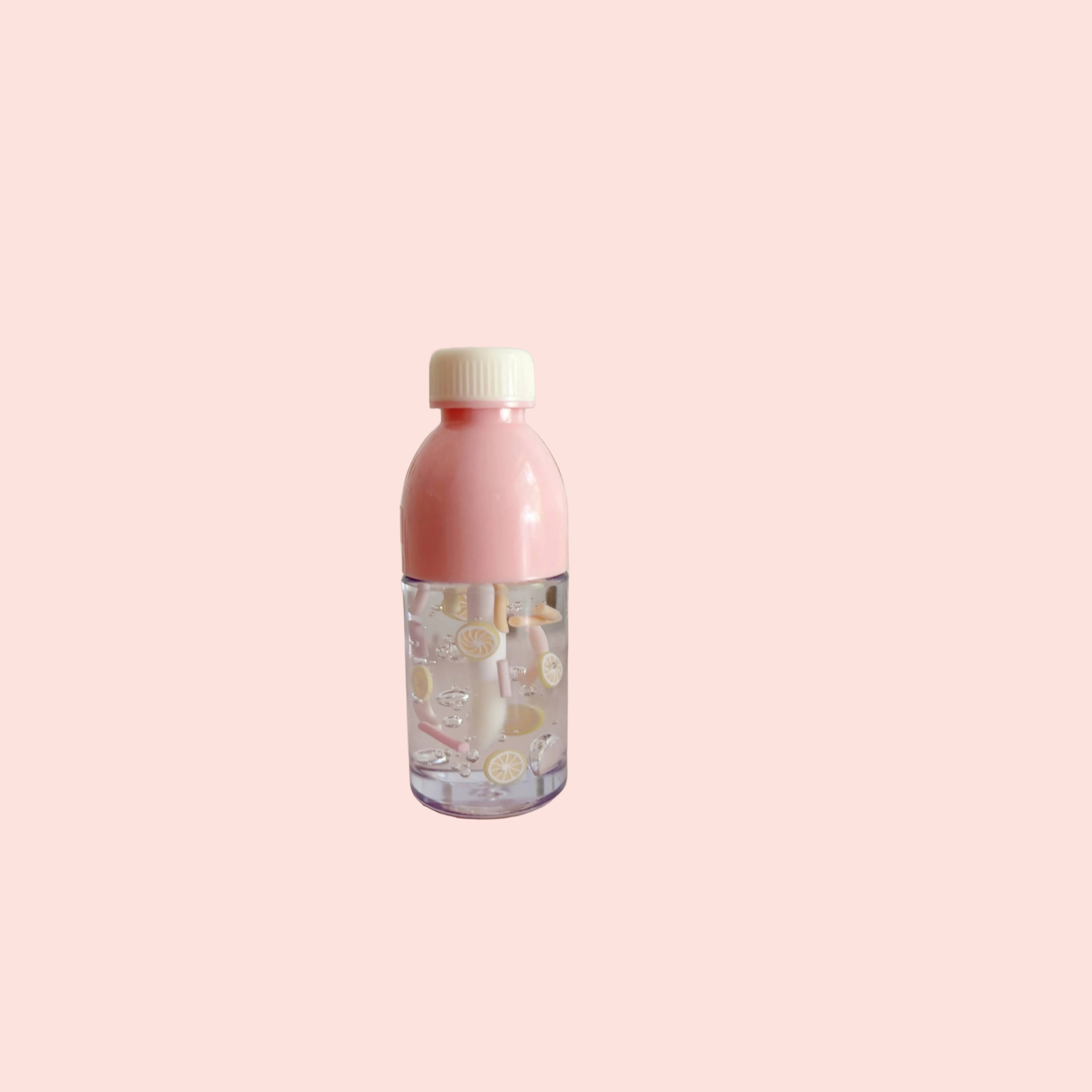 Pink bottle with a patterned label on a pink stand against a polka dot wall.