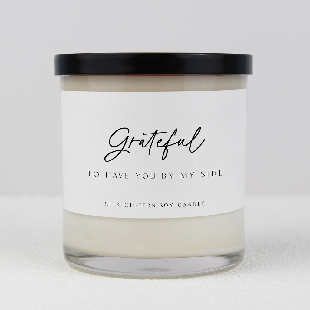 Mother of the Bride Definition Soy Candle in a white glass jar with a sentimental label, displayed on a clear pedestal against a soft pink background.