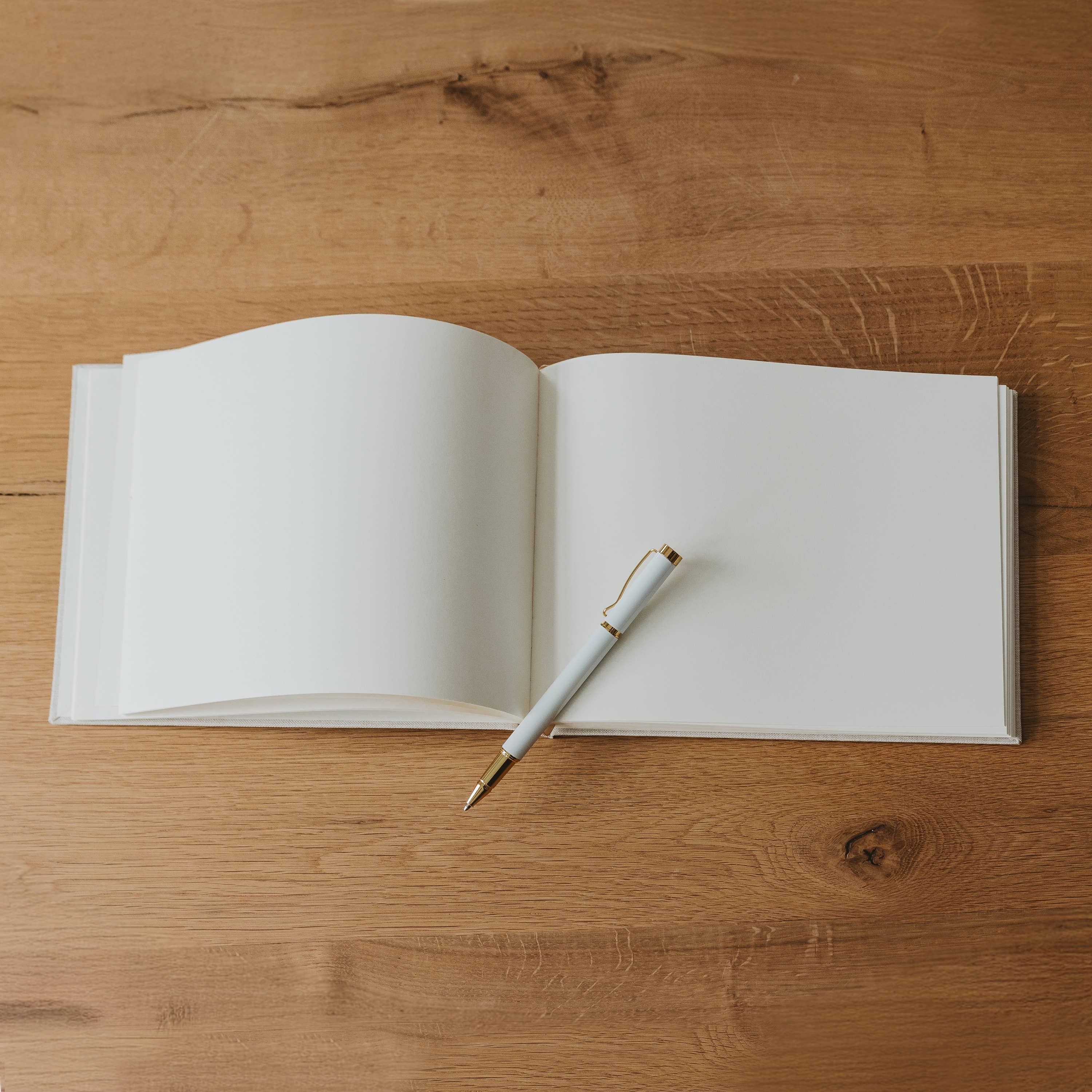 Open notebook with a pen on a wooden surface