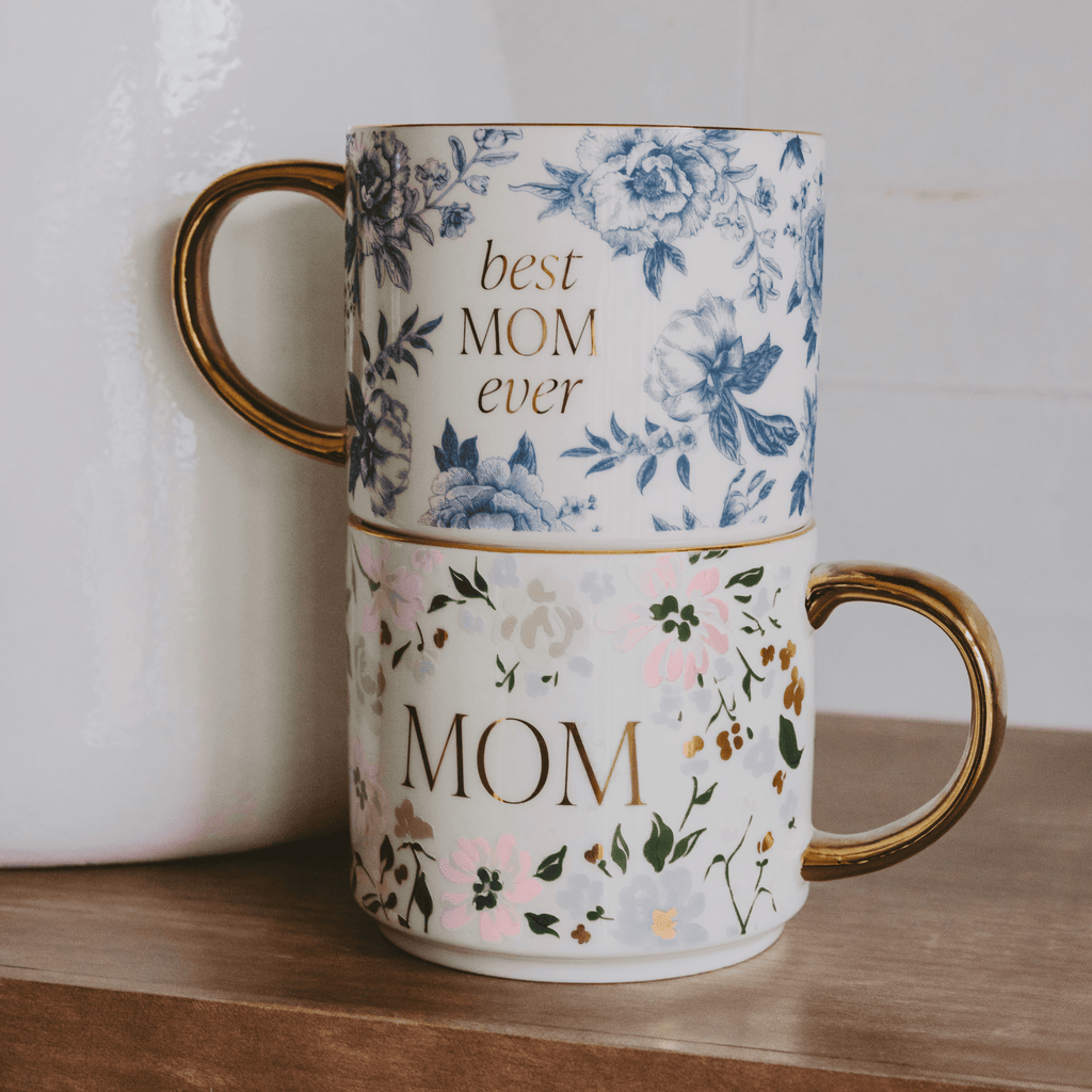 Two floral mugs stacked on a wooden surface with 'best mom ever' and 'mom' text.