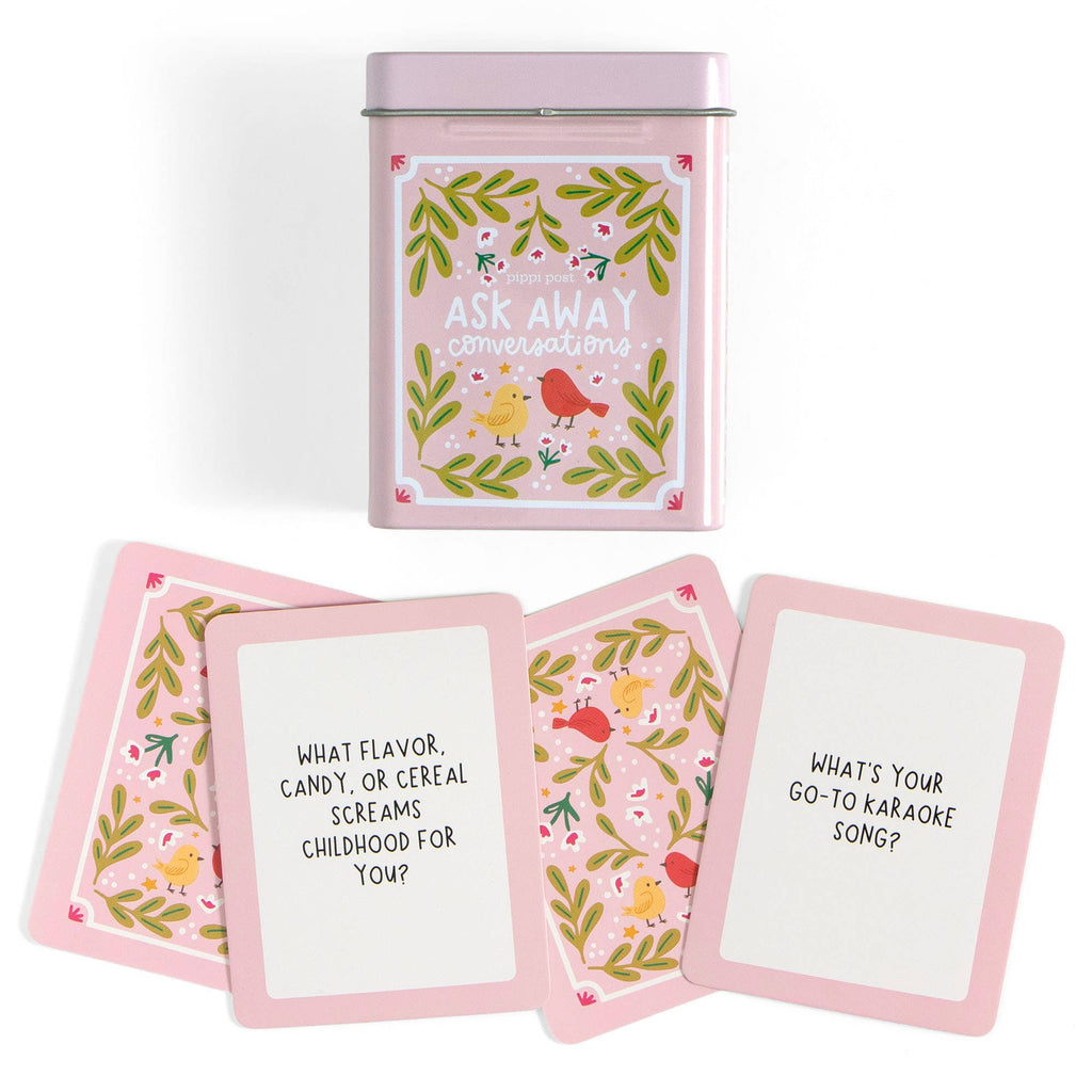 Set of question cards with floral designs and a pink tin container on a white background