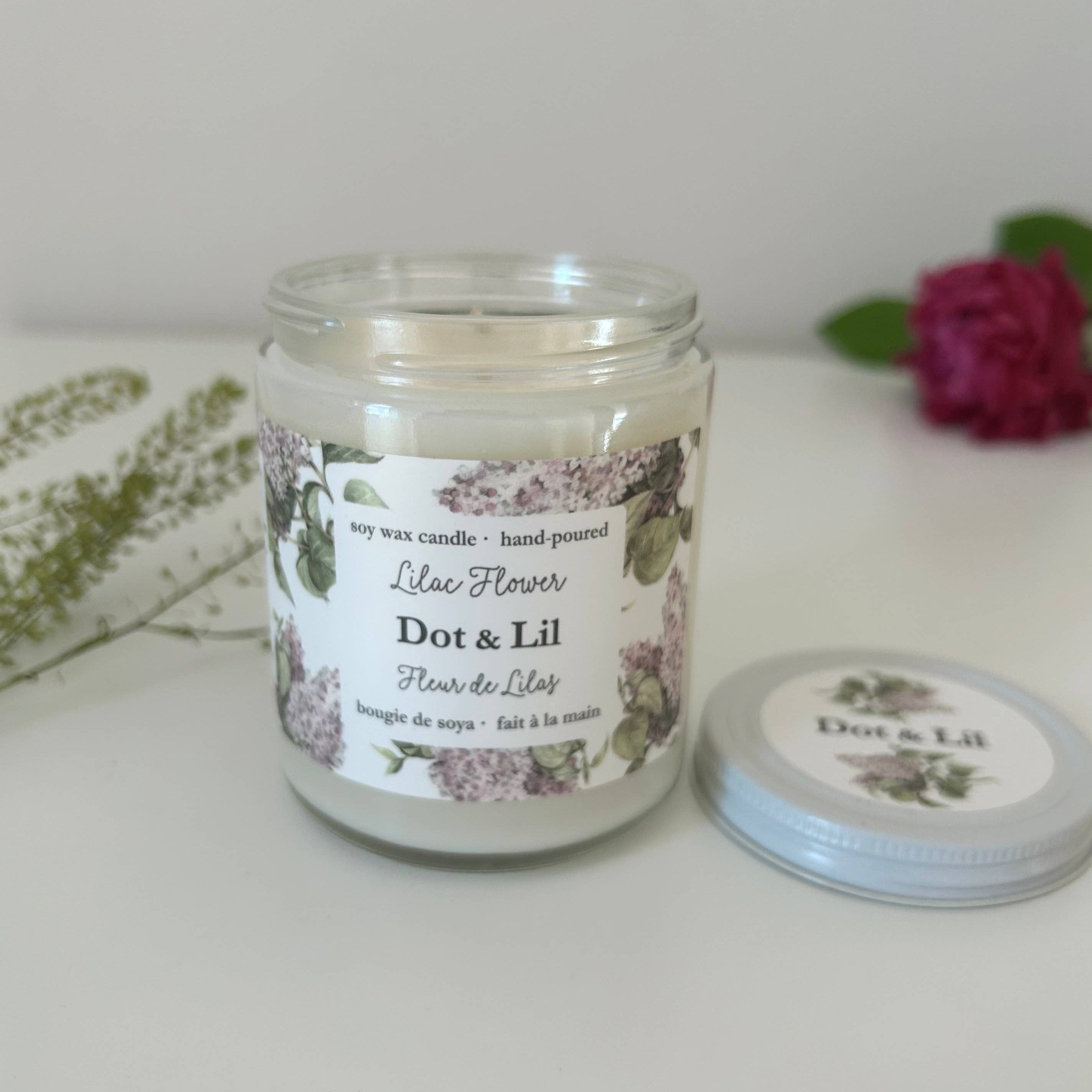 Candle jar with floral label on a white surface