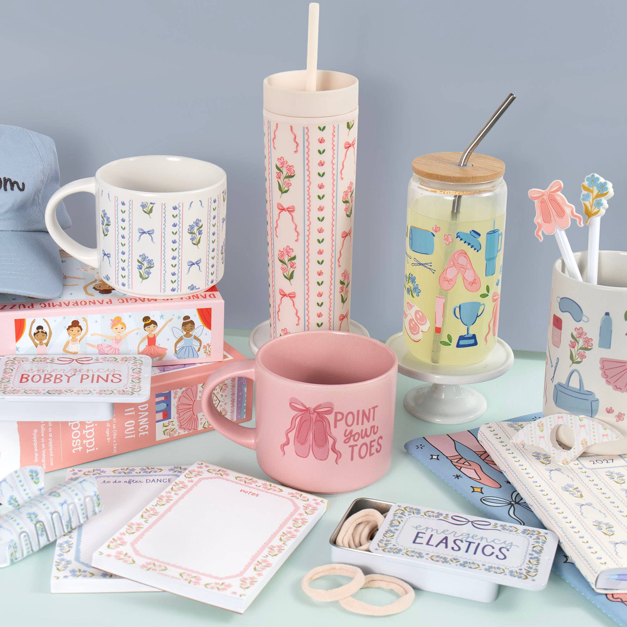 Collection of dance-themed products including mugs, straws, and stationery on a light blue surface.