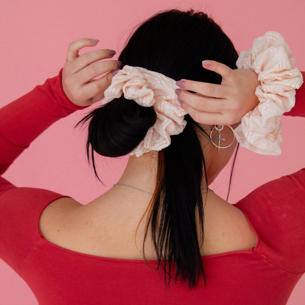 Person wearing a pink headband with ruffles against a pink background